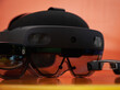 Three different Augmented Reality glasses on an orange and yellow background, close up and isolated views of AR headset