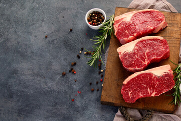 Raw steak on dark background.