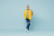 © ViDi Studio - Full body fun elderly gray-haired mustache man 50s wear yellow shirt hold takeaway delivery craft paper brown cup coffee to go isolated on plain pastel light blue background. People lifestyle concept.