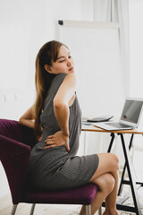 Business woman with back pain in office. Asian people. Work at home concept