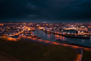 Galway city center illuminated at night. Aerial high point view. Dark scene. Town at night. Popular travel destination. Business and educational center. City lights glow in the dark.