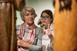 © JENOCHE - Girl with woman looking with interest at art objects under glass in museum