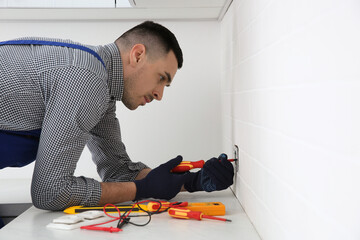 Sticker - Electrician with screwdriver repairing power socket indoors