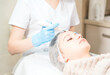 © Dmytro - Cosmetology background. Cosmetologist doing ultrasound face peeling for the young woman.