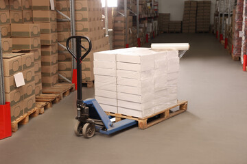 Wall Mural - Manual pallet truck with stacked boxes and roll of stretch wrap in warehouse