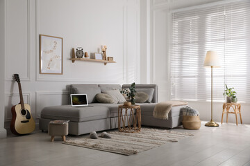 Poster - Living room with comfortable grey sofa and stylish interior elements near window