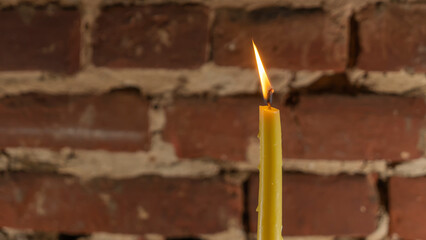 Wall Mural - Candle flame close-up on a light red wall background. Melted Wax Candle light border design. Long Exposure.