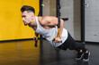 © LIGHTFIELD STUDIOS - Young sportsman training with suspension straps in sports center.