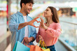 © Prostock-studio - Couple Shopping Making Fingers Heart Holding Shopper Bags In Mall