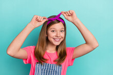 Photo Of Pretty Adorable Kid Girl Tying Headband Before Friend Walk Trip Isolated Over Cyan Color Background