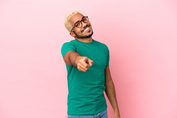 Canvas Print - Young Colombian handsome man isolated on pink background pointing front with happy expression