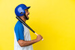 Young Colombian latin man playing baseball isolated on yellow background laughing in lateral position