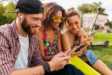 Wall Mural - happy young company of friends sitting park