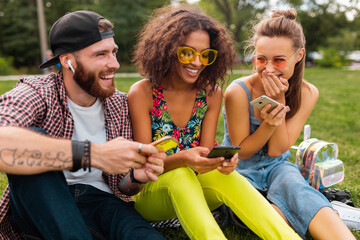 Wall Mural - happy young company of friends sitting park