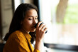 © JustLife - Young businesswoman drinking coffee in her office.