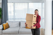 © Srdjan - Young happy woman college student moving in in her new modern studio apartment. Businesswoman holding cardboard boxes with stuff rented new home after she got promoted at work.