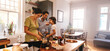 © Jacob Lund - Playful dad feeding his son a slice of bread in the kitchen