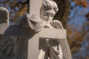 Fototapete - Ancient white statue of angel with cross as symbol of Christianity, death and resurrection of Jesus Christ.