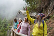 © Sabrina - Multiracial women enjoy trekking day in the mountain forest with stone house in the background