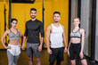 © LIGHTFIELD STUDIOS - Smiling multiethnic friends in sportswear looking at camera in gym.