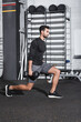 © LIGHTFIELD STUDIOS - Side view of arabian sportsman doing lunges with dumbbells in gym.