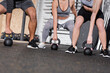 © LIGHTFIELD STUDIOS - Cropped view of people working out with kettlebells in sports center.