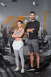 © LIGHTFIELD STUDIOS - Positive muslim sportsman crossing arms near middle east sportswoman in gym.