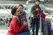 © NFstock - Smiling family with child at the airport. Happy mother embracing her little daughter while her husband standing at the background