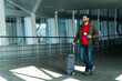 © NFstock - Im ready for the journey. Full length view of the male tourist is standing at the airport and carrying his suitcase. Man is holding his passport