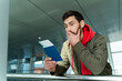 © NFstock - Waist up portrait of shocked man standing at the airport and looking at his passport with surprised expression while waiting for departure. Technologies and people concept