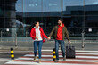© NFstock - Full length shot of the happy married couple holding hands of each other while going from the airport with their suitcase. Traveling concept