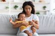 © Prostock-studio - High Fever. Concerned Black Mom Checking Temperature Of Her Crying Infant Baby