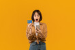 © Prostock-studio - Bonus and cashback concept. Surprised young lady showing debit credit card, using smartphone, making online payment