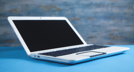 Wall Mural - white laptop on the blue business desk.