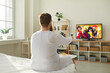 © Studio Romantic - Plump ginger guy wakes up in morning and switches television with remote control. Funny fat man in PJs sitting in bedroom at home and watching entertainment channel on widescreen HD LED TV, back view