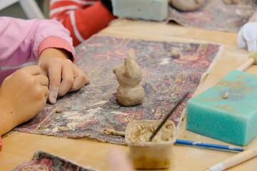 Wall Mural - A child molds a product from clay in a modeling lesson.