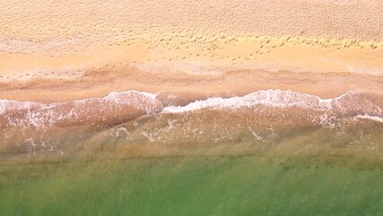 Aerial view of sand beach. Top view sea waves. Drone footage