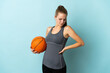 © luismolinero - Young woman playing basketball isolated on blue background suffering from backache for having made an effort