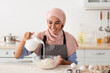 © Prostock-studio - Homemade Recipes. Happy Muslim Lady In Hijab And Apron Baking In Kitchen