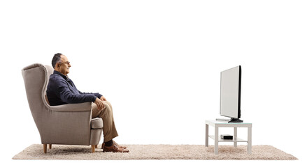 Sticker - Profile shot of a casual mature man sitting in an armchair and watching tv