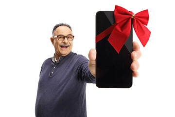 Sticker - Smiling mature casual man holding a mobile phone with a red ribbon in front of camera