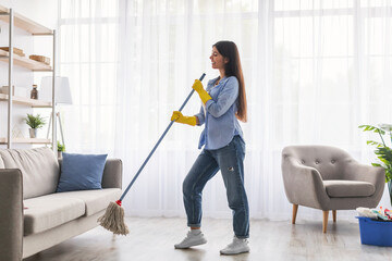 Wall Mural - Woman cleaning floor singing and holding mop