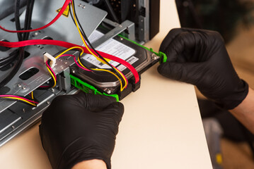 Wizard repairs personal computer with tools and hands. Disassembly of the computer into spare parts