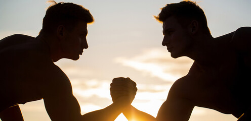 Poster - Silhouette of hands that compete in strength. Rivalry, closeup of male arm wrestling. Men measuring forces, arms. Two men arm wrestling. Rivalry, vs, challenge, hand wrestling. Sunset, sunrise