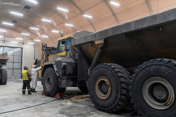 A mechanic repairs an articulated dump truck.