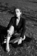© Yevhen - Black and white portrait of a young girl in the city park. Elegant and melancholy portrait, the girl is sitting on the grass. Beautiful woman in classic clothes