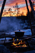 Outdoor Cooking On An Open Fire With Sunset In The Background