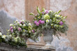 Romantischer Hochzeitsstrauß in einer barocken Steinvase vor der Chiesa di San Giuseppe in Taormina in Italien