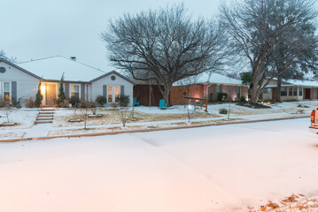 Wall Mural - Wintertime quiet residential street covered in snow and ice with light poles in suburbs Dallas, Texas, America