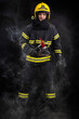 © blanke1973 - Firefighter fully equipped with helmet and ax in smoke, black background